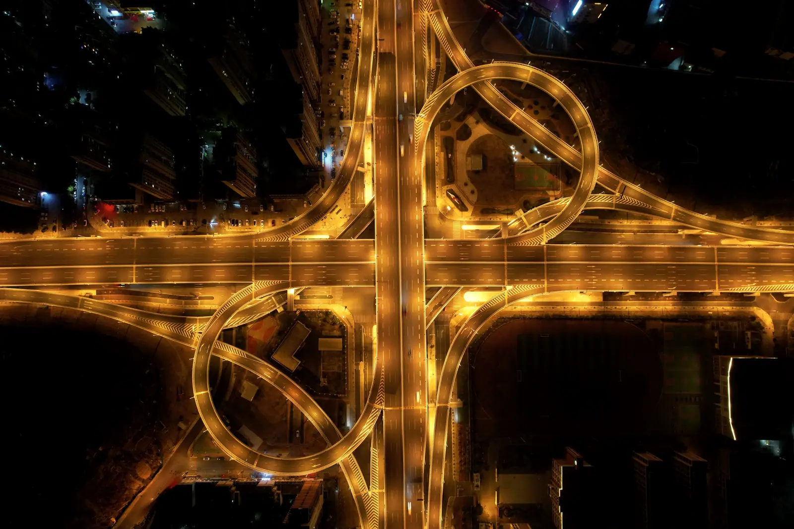 A highway interchange lit up at night, seen from above